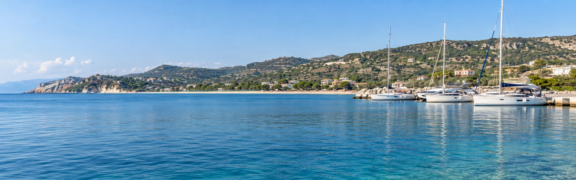 Calm water and resting yachts beside the low hills of Lalëz Bay on Albania’s Adriatic coast.
